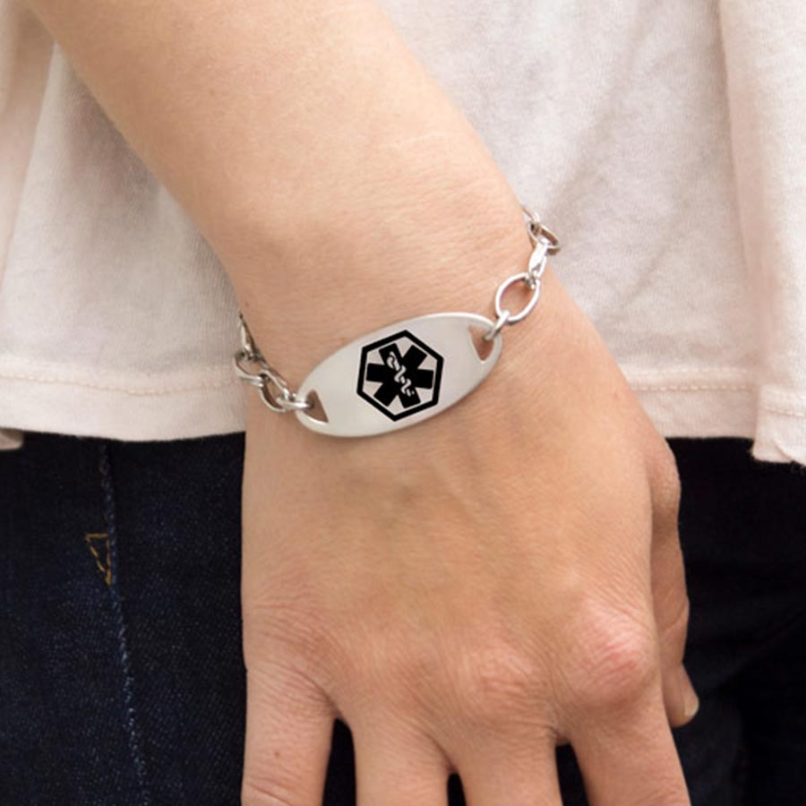 Woman wearing the oval-shaped silver-tone Stainless Black Oval Medical ID Tag with black medical caduceus on an LH bracelet