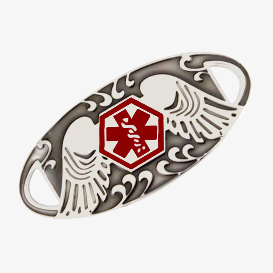 Silver tone tag with patina in the recessed area features angel wings and red medical alert icon.