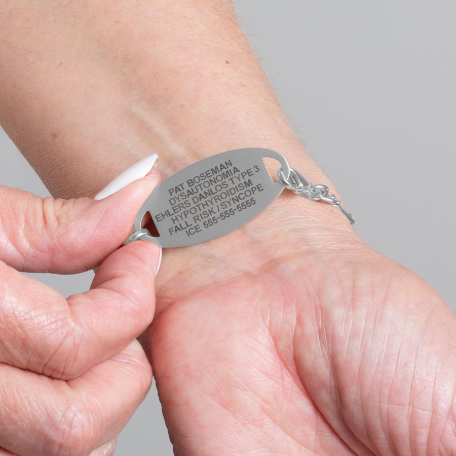 Woman showing custom laser engraved medical ID tag in stainless steel