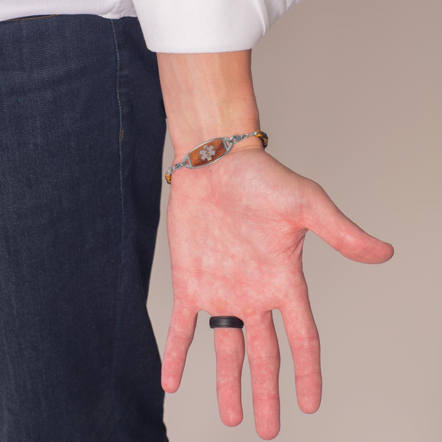 Man wearing stainless steel medical ID tag with cedar-tone wood inlay.