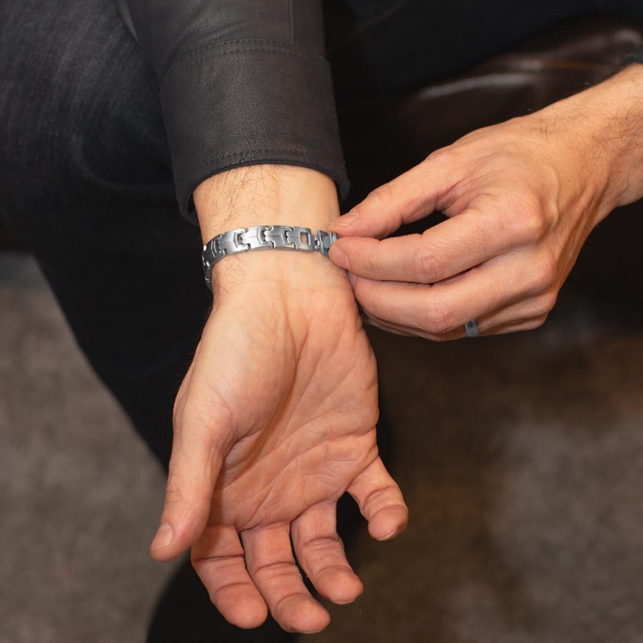 Man showing closure on stainless steel link style medical alert bracelet.