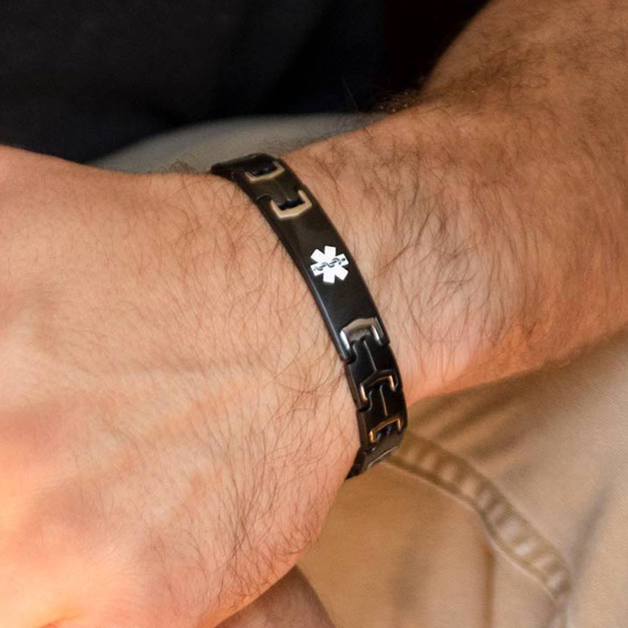 Man wearing Black Stealth Medical ID Bracelet. Stainless bracelet with matte black finish, white caduceus, stainless accents