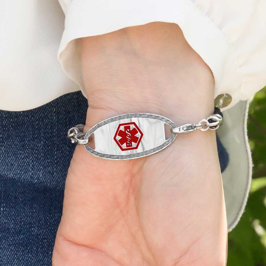 Woman wearing Black Macrame Medical ID Bracelet with stainless oval medical ID tag with border design and red caduceus