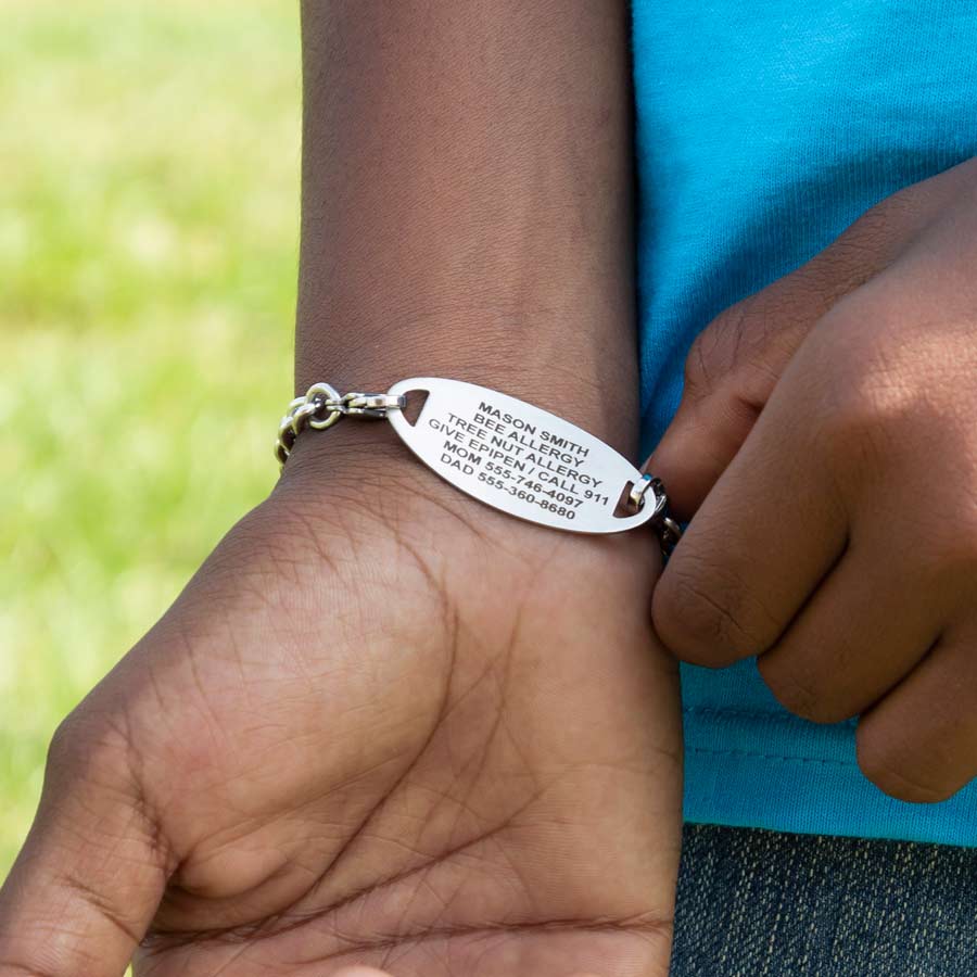 Boy showing custom laser engraved medical ID tag