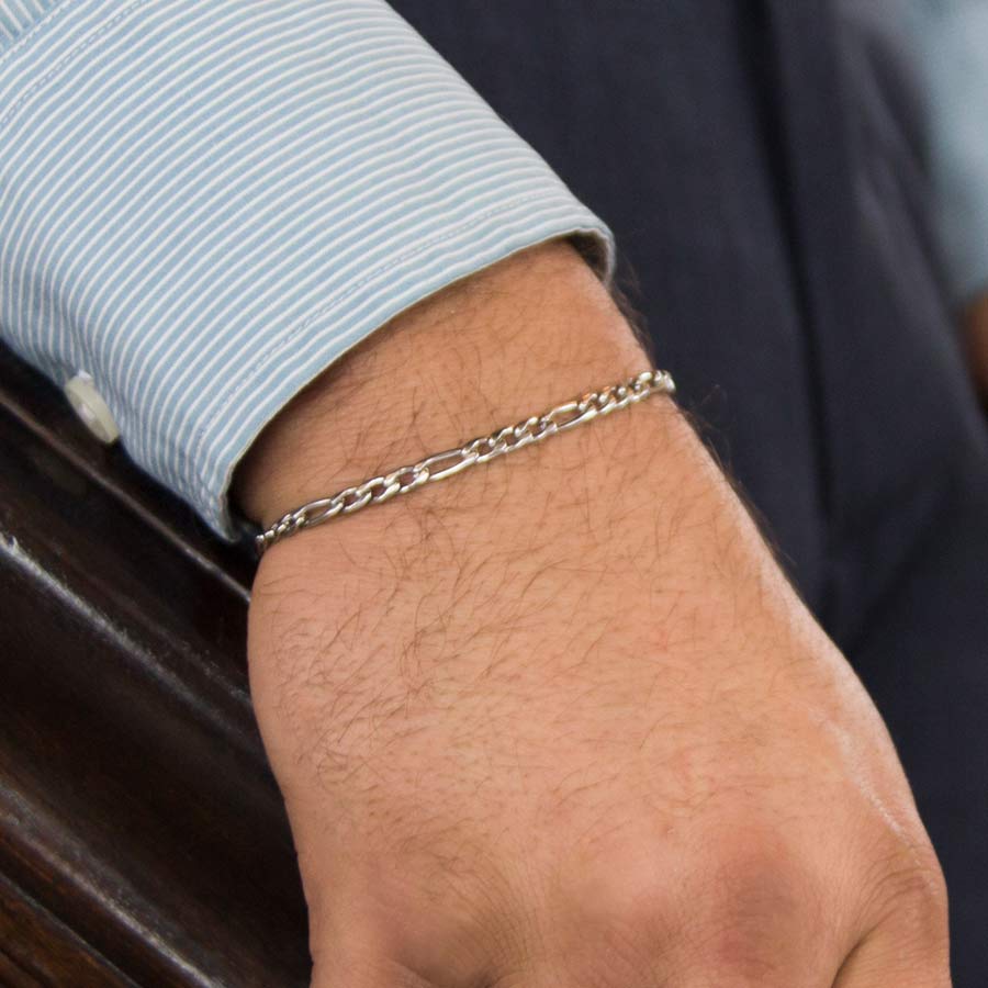 Man holding stair rail and wearing small stainless steel chain medical ID bracelet