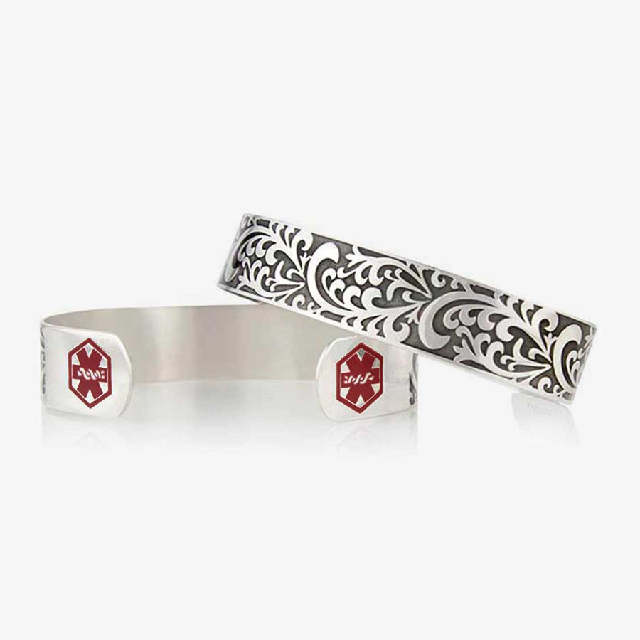 Front, back of Filigree Medical Alert Cuff. Silver tone stainless cuff. Intricately scrolled design and red caduceus each end