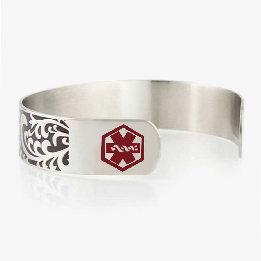 Side of Filigree Medical Alert Cuff. 1/2&quot; wide silver tone stainless cuff. Intricately scrolled design. Red caduceus each end