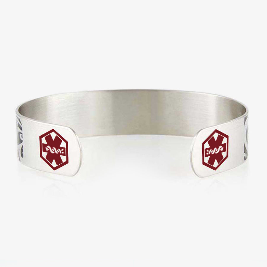 Back of Filigree Medical Alert Cuff. Silver tone stainless cuff. Intricately scrolled design and red caduceus each end