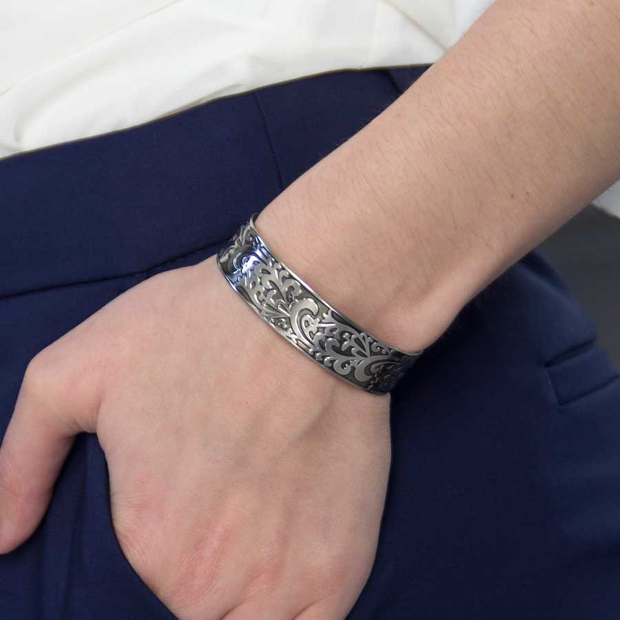 Woman wearing Filigree Medical Alert Cuff. Silver tone stainless cuff, intricately scrolled design with dark patina inlay