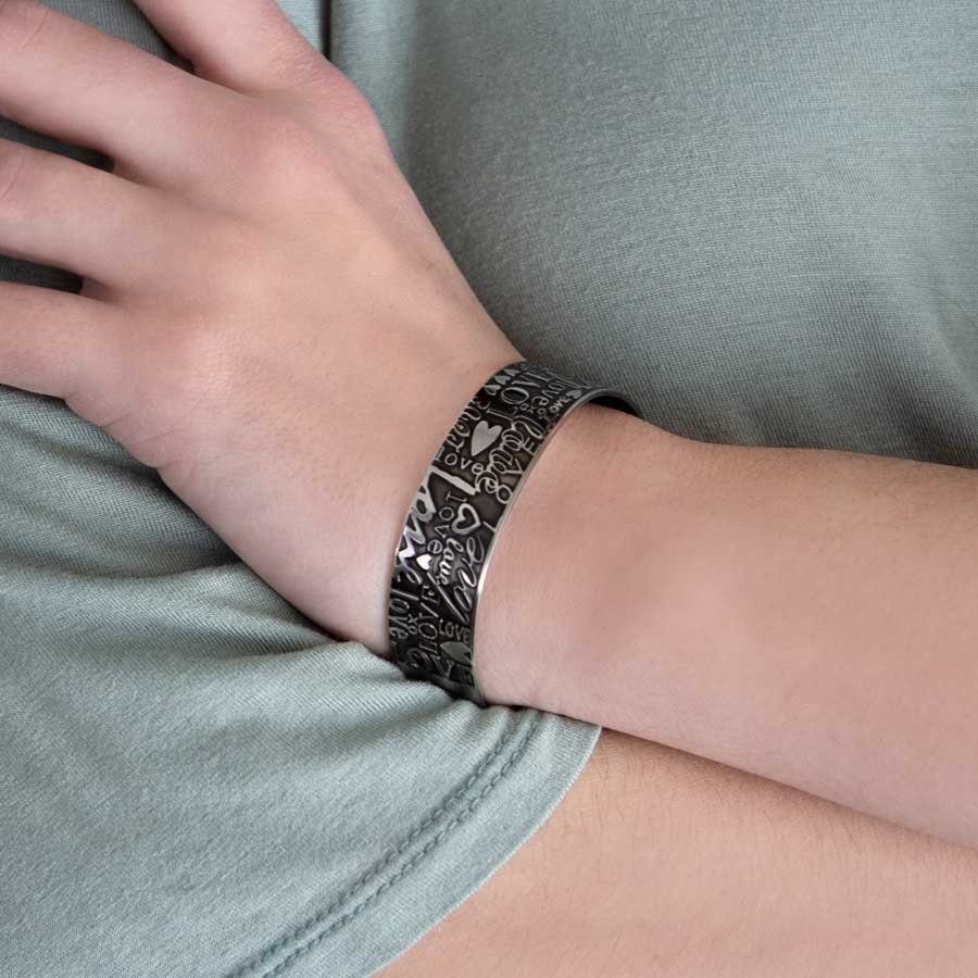 Woman wearing stainless steel cuff medical alert bracelet with &quot;love&quot; inscriptions