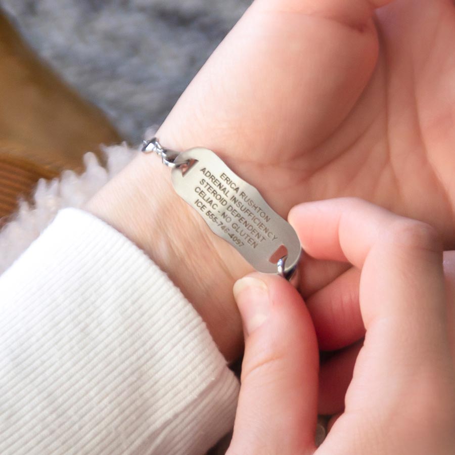 Woman showing custom laser engraved silver tone medical alert tag