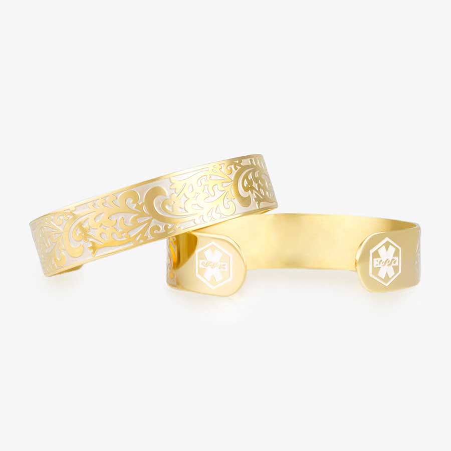 Gold tone medical alert with decorative filigree swirl pattern in pearl inlay with pearl medical alert symbols