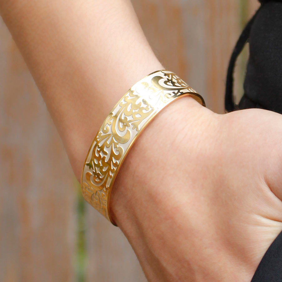 Woman wearing Golden Filigree Medical ID Cuff. Front of stainless yellow gold tone filigree cuff with pearlescent finish