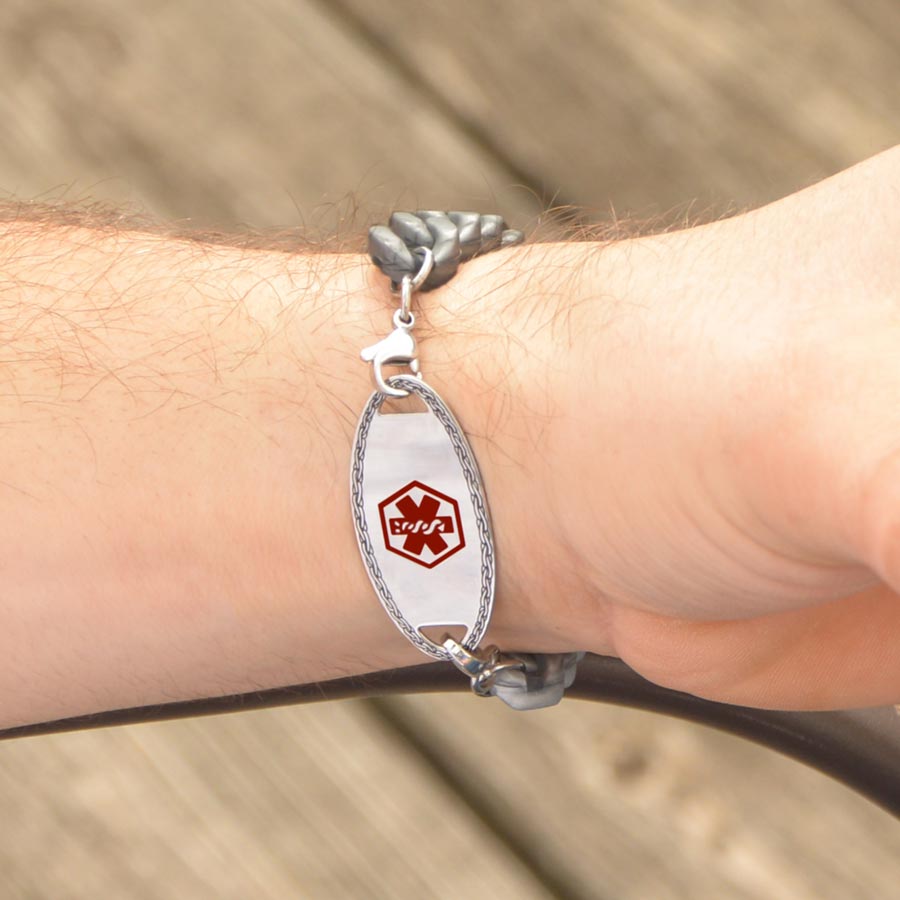 Man wearing silver medical ID tag with red medical symbol