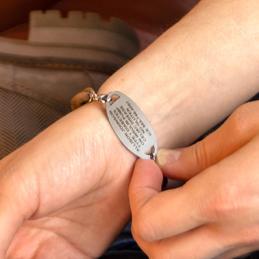 Woman showing custom premium laser engraving on silver medical ID tag