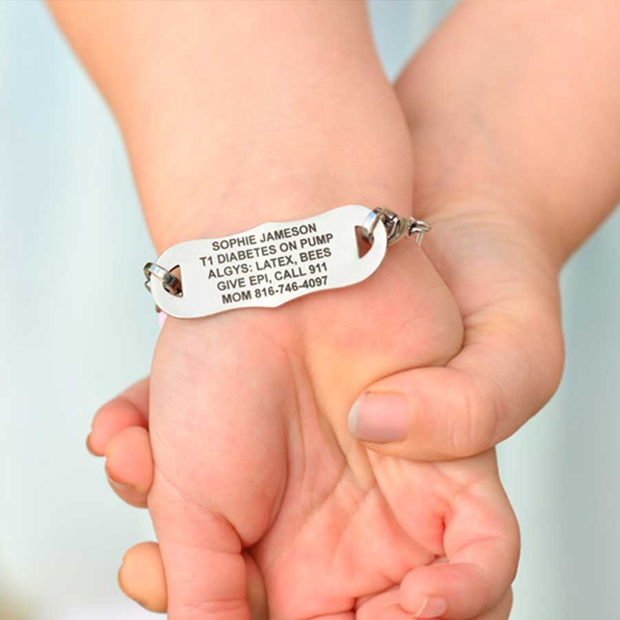 Girl showing custom laser engraved medical ID tag