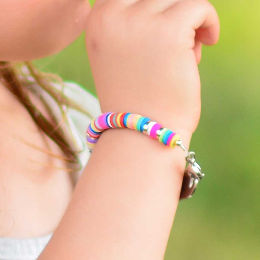 Young girl wearing colorful beaded medical ID bracelet with multicolored disc beads