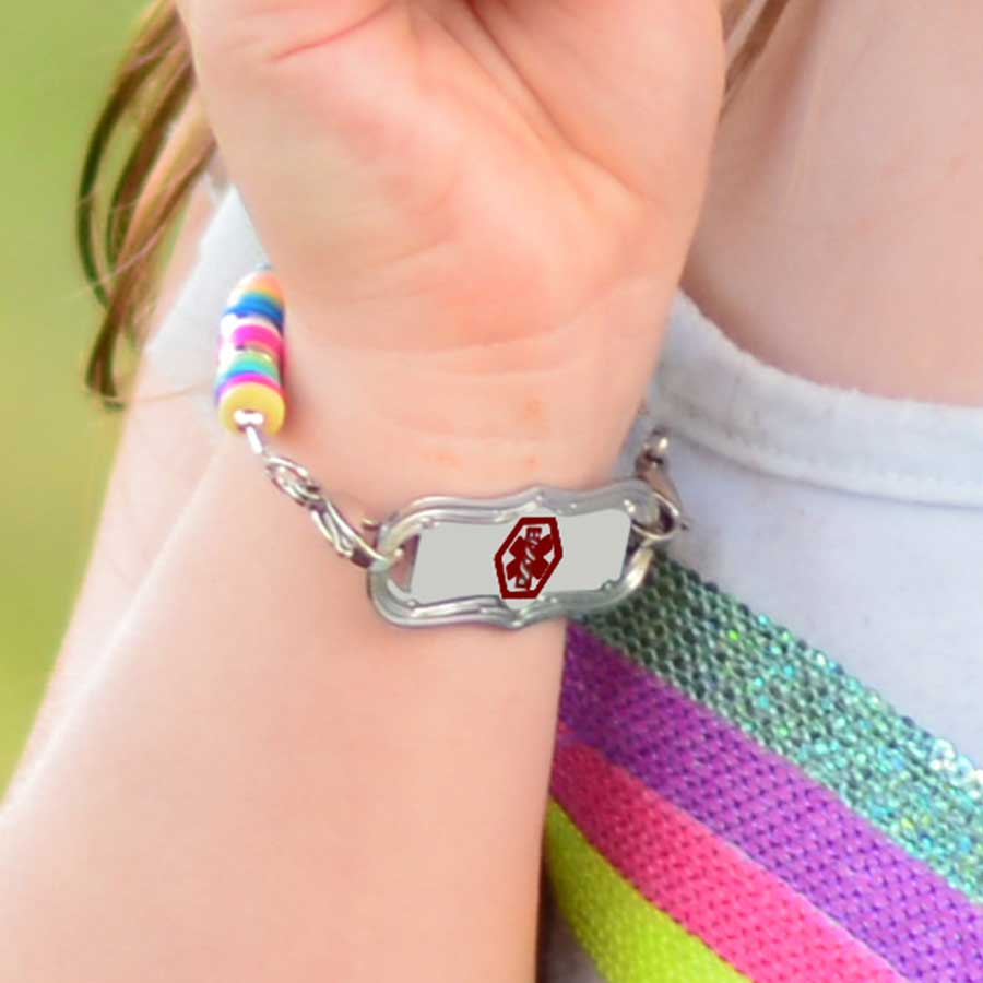 Little girl showing medical alert tag on colorful medical ID bracelet