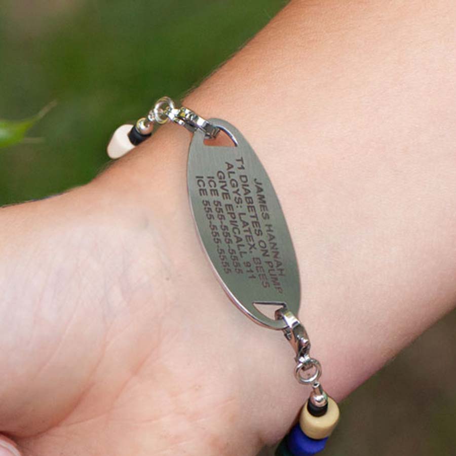 Boy showing custom laser engraved medical ID tag.