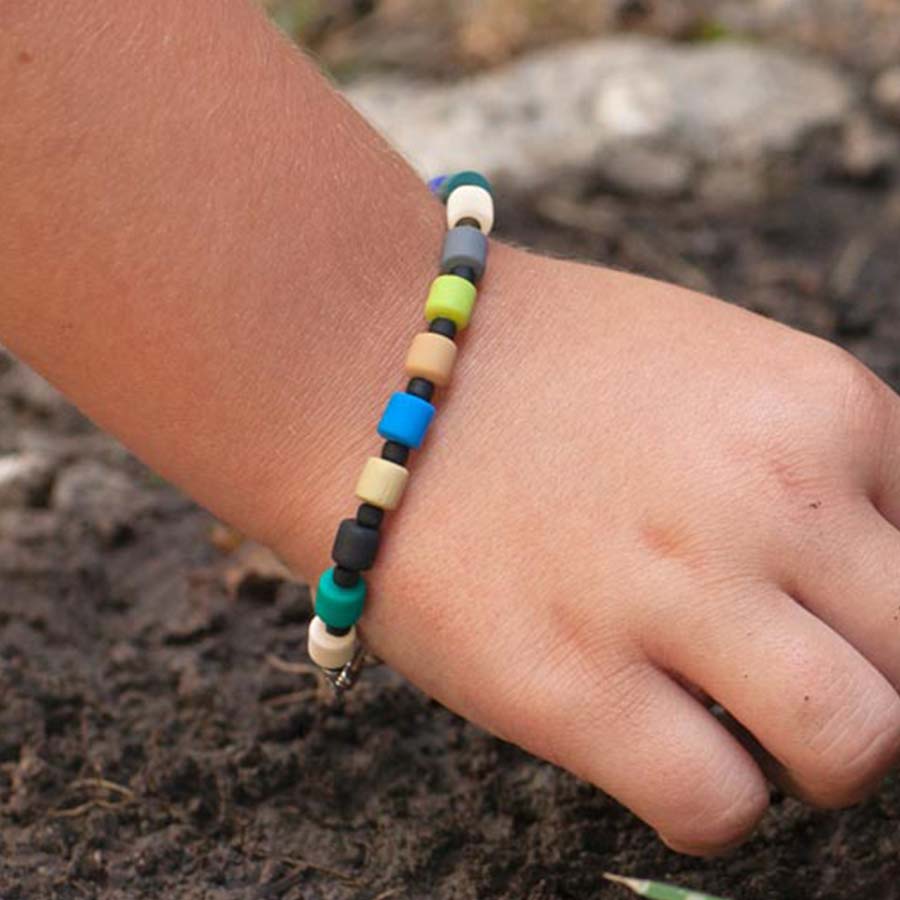 Young boy wearing earth tone beaded medical ID bracelet.