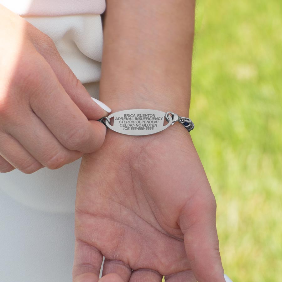 Woman showing premium laser engraving on stainless steel medical ID tag.