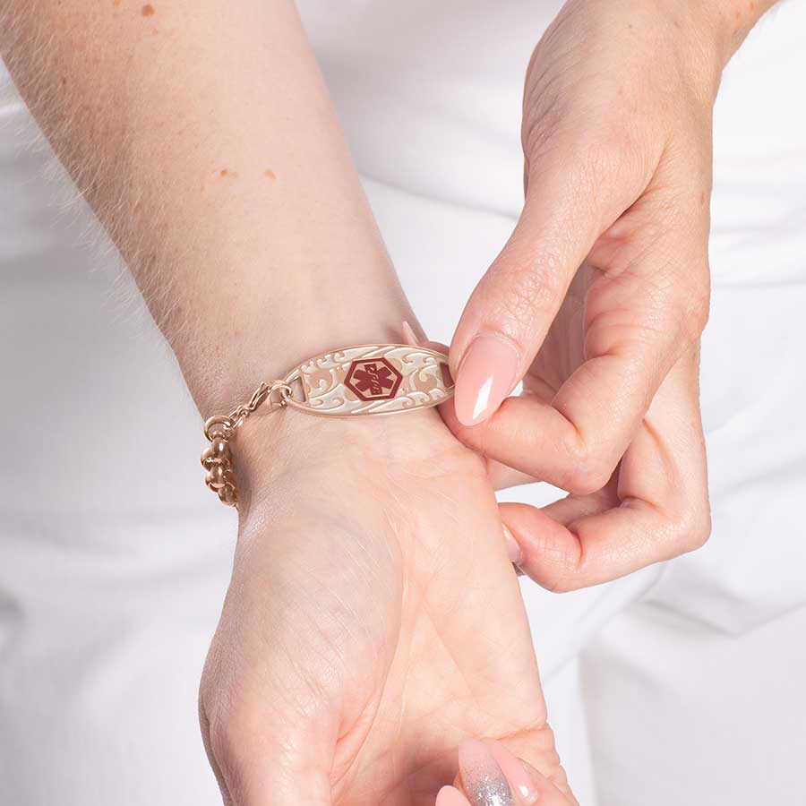 Woman showing front side of rose gold tone stainless steel medical ID tag.