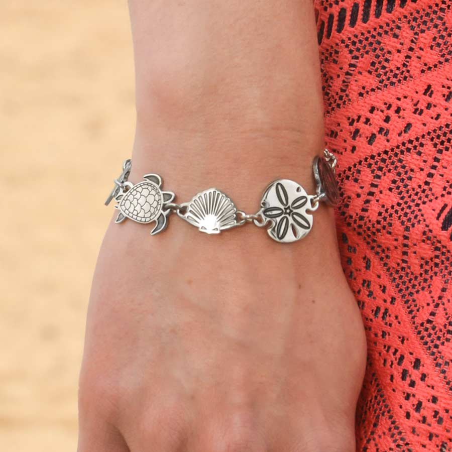 Woman wearing the silver tone stainless Sea Life Medical ID Bracelet with the sea turtle, shell and sand dollar links visible