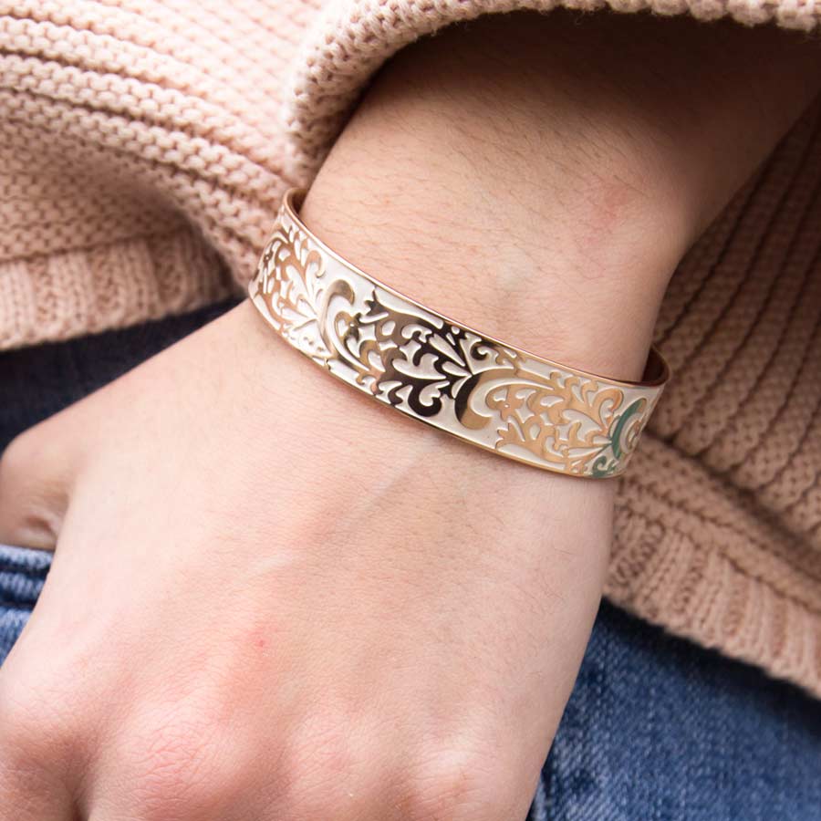 Woman wearing the plated stainless Rose Gold Tone Filigree Medical ID Cuff with intricate scroll design, pearlescent inlay