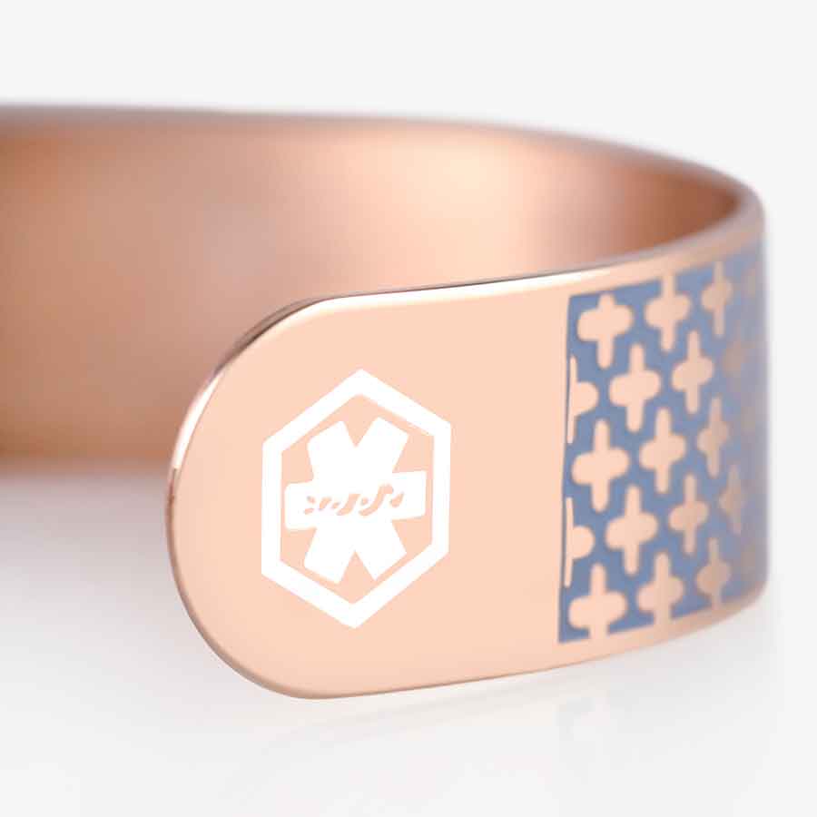 Side of rose gold medical ID cuff with medical caduceus symbol embossed in white pain