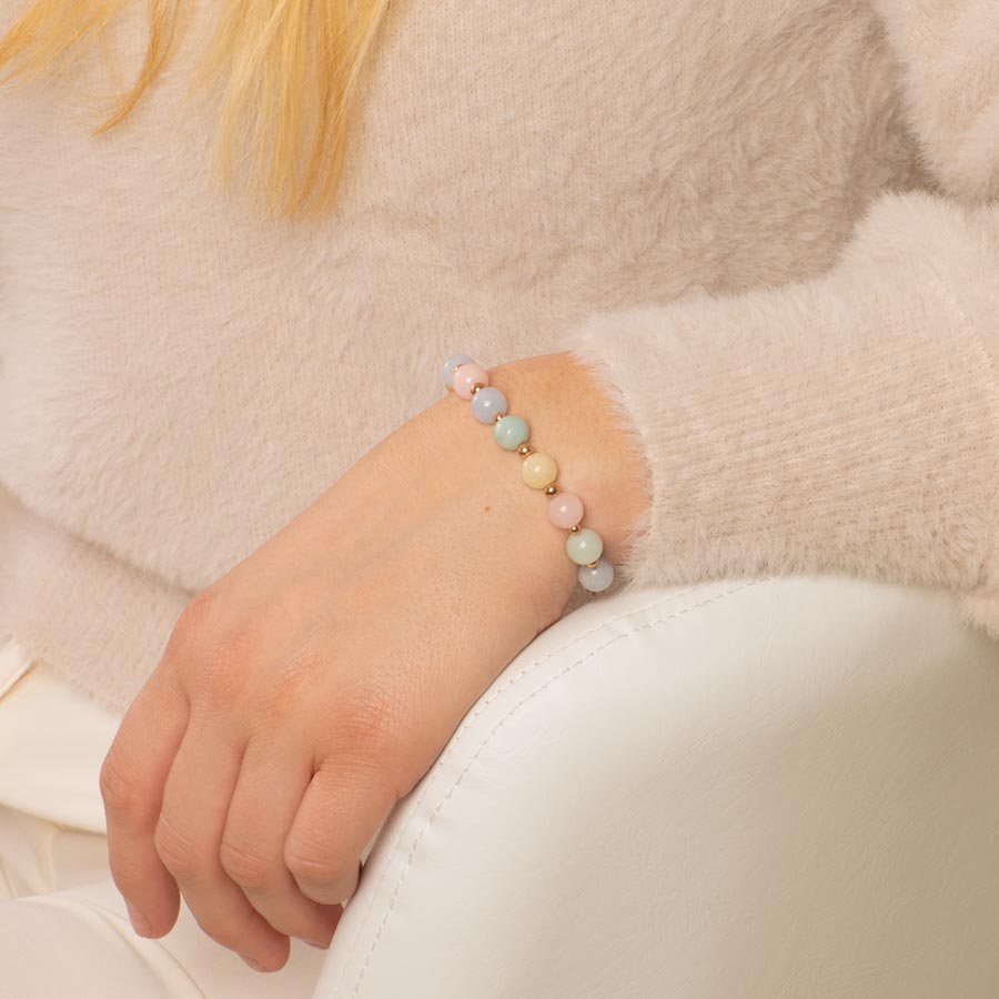 Woman wearing pink, white, and blue beaded medical ID bracelet with rose gold accents.