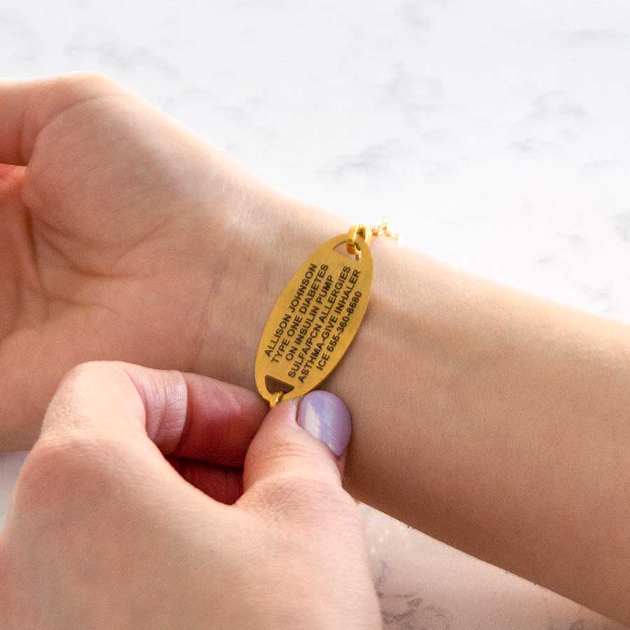 Woman showing custom laser engraved medical ID tag