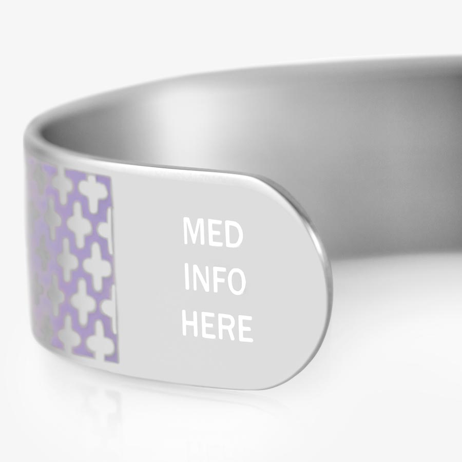 A close up view of silver tone medical ID cuff bracelet with lavender pattern and white &quot;med info here&quot; at the end of the cuff.