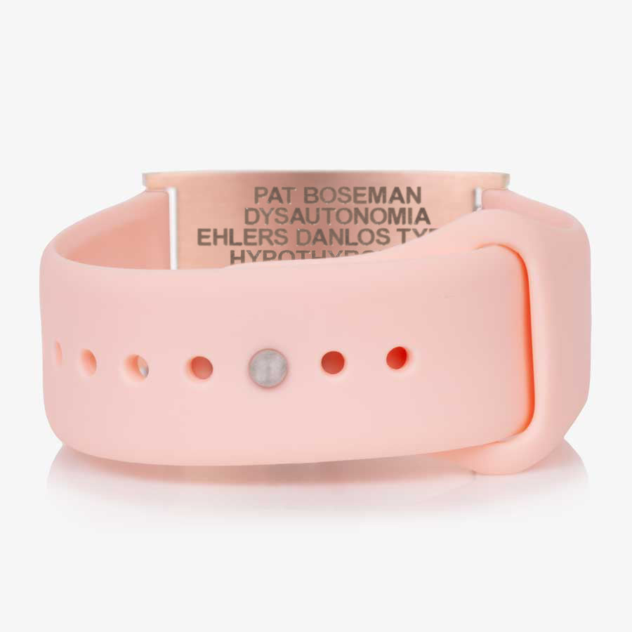 Low back angle of pink silicone band with adjustable strap and a rose gold tag with white caduceus symbol.