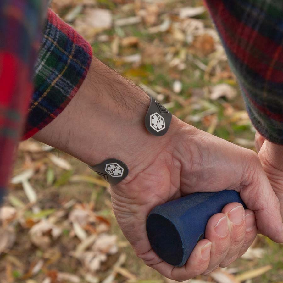 Man wearing black sandblasted medical ID alert cuff with white medical symbols