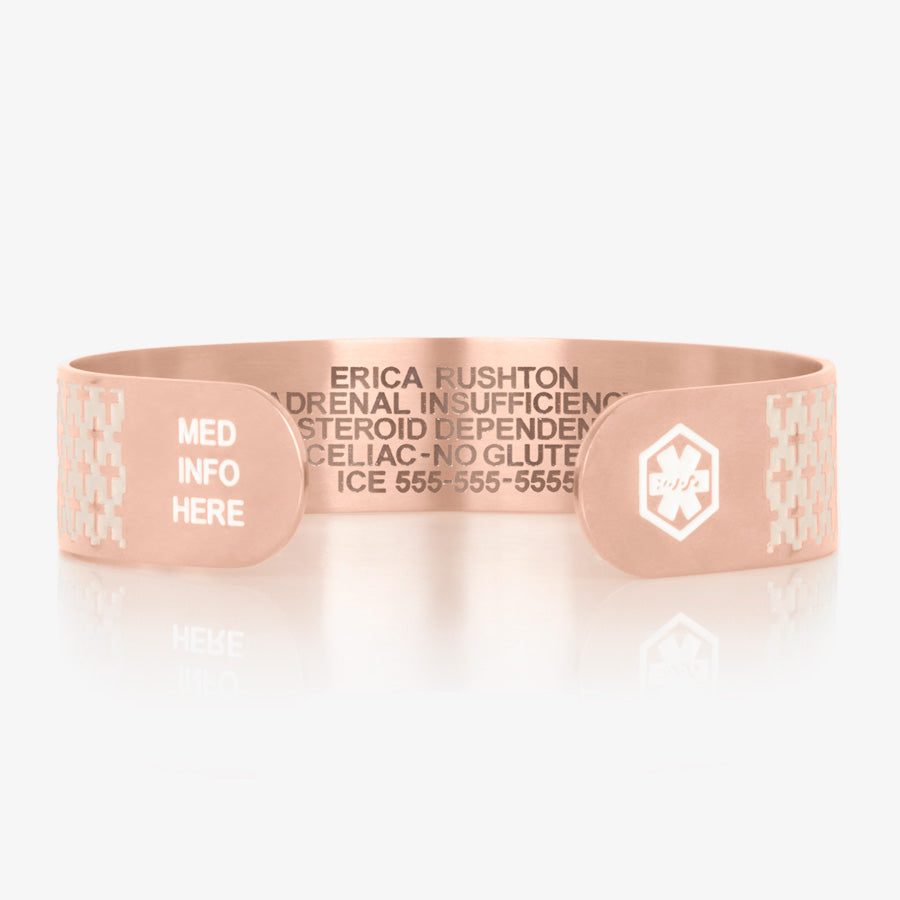 Rose gold tone stainless steel medical alert cuff bracelet with pearlescent inlay on with cross detailed pattern and white medical symbols and &quot;med info here.&quot;