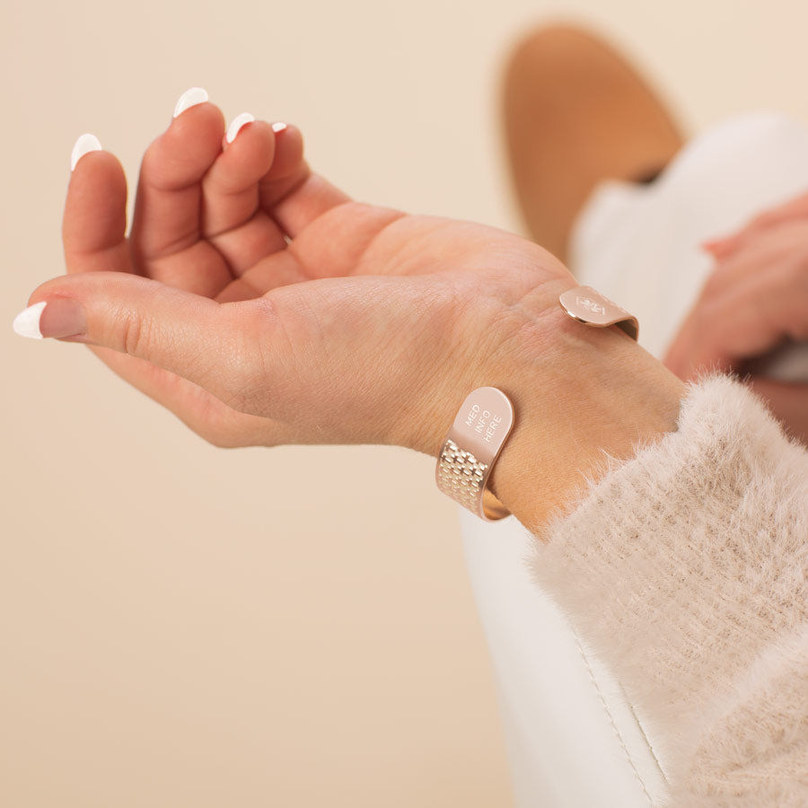 Woman showing medical info on rose gold medical ID cuff bracelet