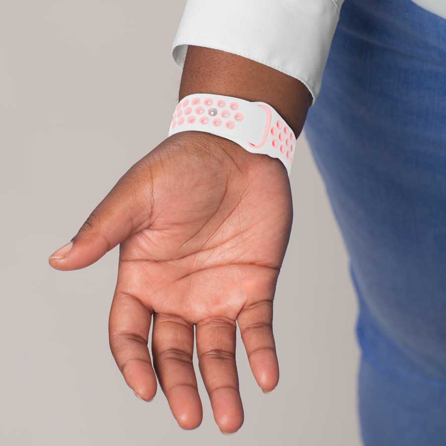 Woman showing back clasp of white and peach silicone activewear medical ID band