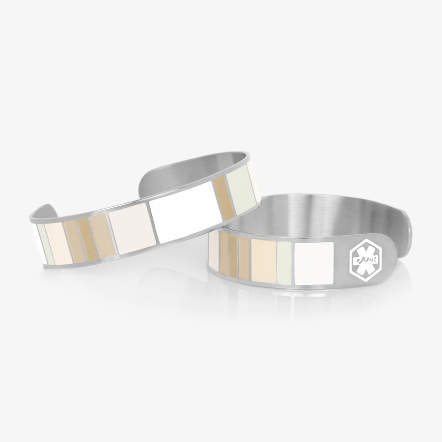 Color block medical ID cuff in varying shades of tan, brown and white with white medical symbols at each end