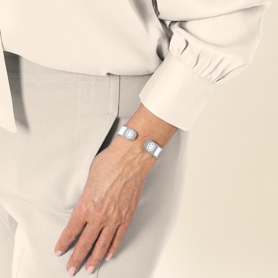 Woman wearing color block medical alert cuff bracelet in varying shades of brown and tan