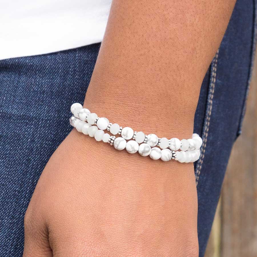 Woman in white top and dark jeans with hand at side wearing moonstone, crystal, and white jade two strand beaded stretch medical ID bracelet.