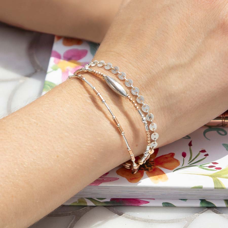 Woman wearing rose gold and silver medical alert bracelet with beads