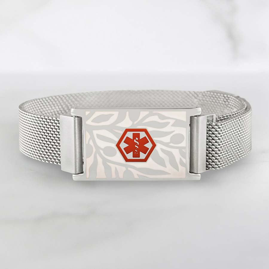 Front of silver-tone stainless Urban Medical Alert bracelet with floral design on marble background