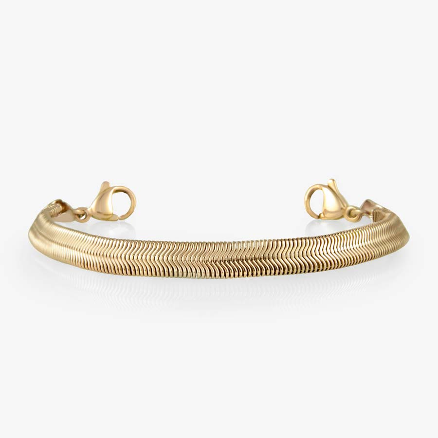 Overhead shot of gold herringbone medical ID bracelet strand on white background.