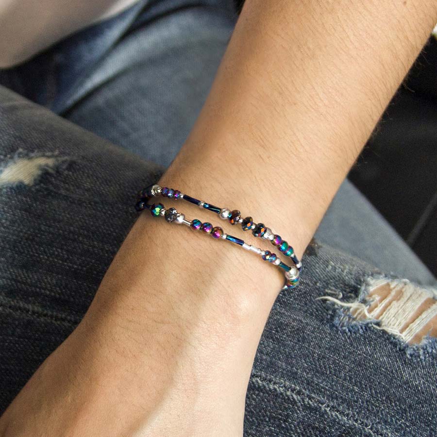 Woman wearing beaded blue and purple medical ID bracelet with silver accents