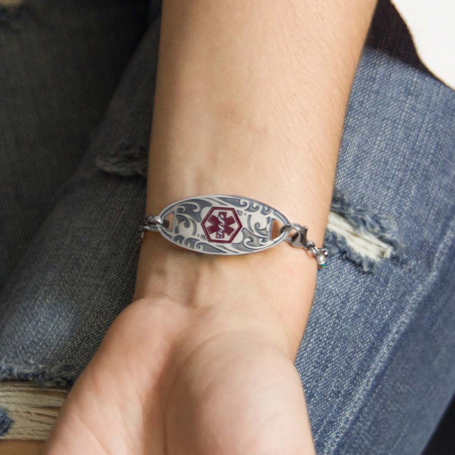 Woman wearing decorative silver medical alert tag on beaded bracelet