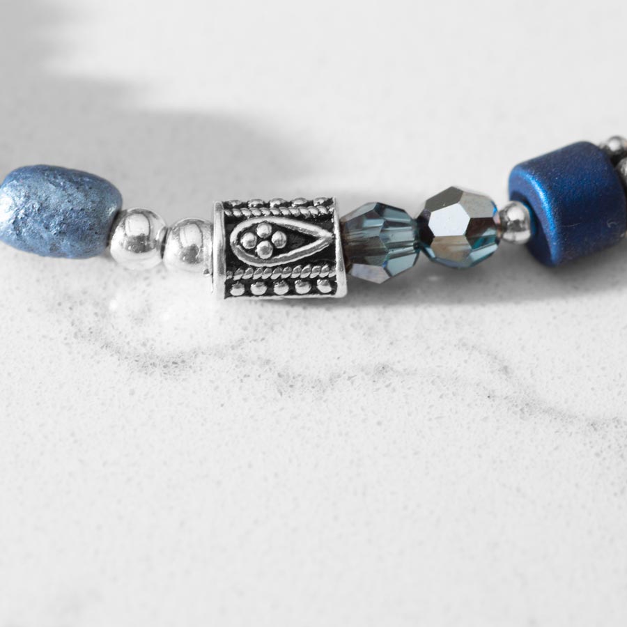 Close up of Blue and silver beaded medical ID bracelet on jewelry elastic with stainless steel lobster clasps and sapphire blue decorative med ID tag.