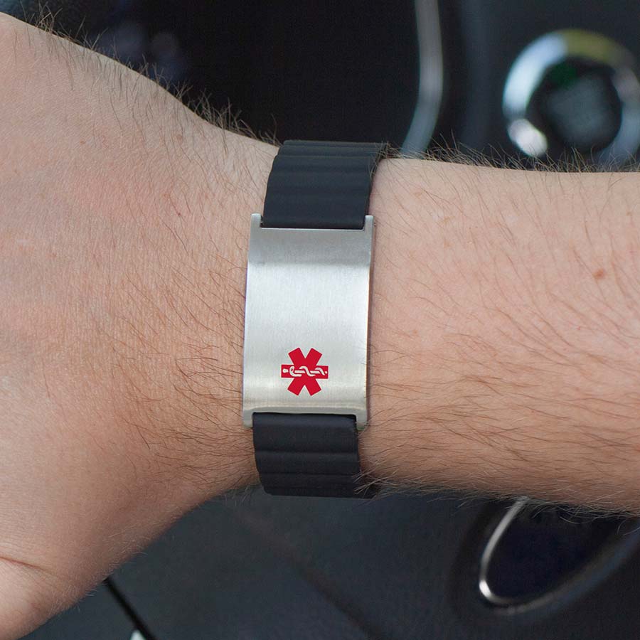 Man opening car door wearing black magnetic medical ID bracelet with silver tag and red medical symbol.