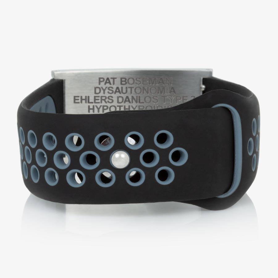 Low back angle of black and grey perforated silicone band with adjustable strap and a brushed silver tag.