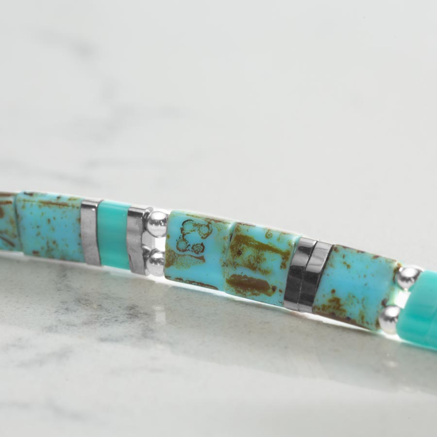 Close up image of turquoise tila beads.