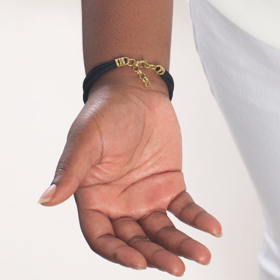 Woman showing custom laser engraved gold medical ID tag with decorative edges